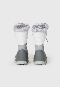 Botas impermeables grises y blancas con un cuello gris esponjoso, suela gris texturizada y cordones ajustables, diseñadas para uso en clima frío.