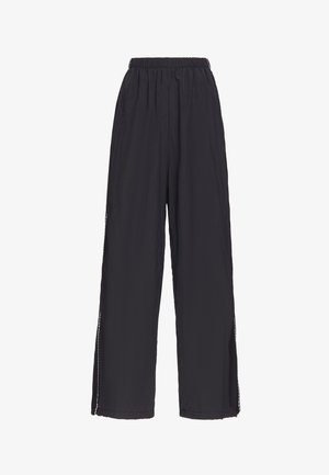 Schwarze weite Hose mit elastischem Bund und seitlichen Schlitzen, aus leichtem, leicht strukturiertem Stoff gefertigt.