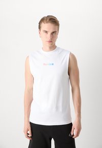 Camiseta sin mangas de algodón blanca con el texto multicolor "Esto es Amor" en el pecho. Textura suave, cuello redondo y corte relajado.