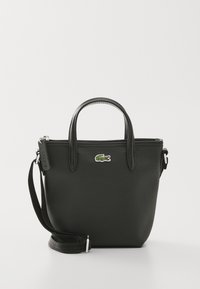 Sac fourre-tout synthétique noir avec doubles poignées, bandoulière amovible, fermeture éclair et accent du logo crocodile vert de Lacoste.