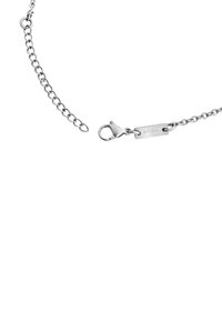Zilveren metalen kettingarmband met een karabijnsluiting en een platte tag met het "BREIL" logo, die een gladde textuur en uniforme schakels toont.
