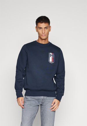 Felpa in cotone blu navy con collo a giro, maniche lunghe, polsini e orlo a costine; presenta una grafica del logo sulla parte superiore sinistra del petto.