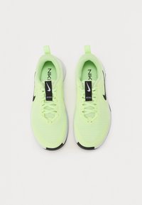 Limoengroene Nike-sneakers met een bovenwerk van mesh, zwarte accenten en een contrasterende witte zool. Voorzien van veters en een zwart label met "Just Do It."
