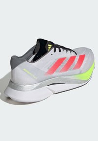 Leichte Laufschuhe mit einem grauen Obermaterial aus Mesh, roten und gelben Akzenten, gepolsteter Sohle und einem schlanken, aerodynamischen Design.