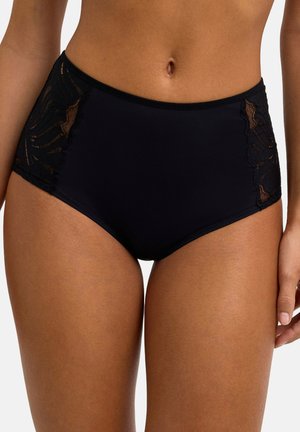 Culottes taille haute noires avec panneaux latéraux en dentelle portées par une personne, montrant le ventre et le haut des cuisses sur un fond blanc.