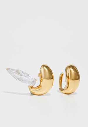 Zelta tonis metāla auskari ar gludu apdari un marquise formas caurspīdīgu kristālu akcentu. Elegants, izliektas formas dizains ar atvērtu aizmuguri.