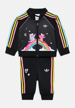 Ensemble de sport noir pour tout-petit avec manches et pantalons rayés aux couleurs de l'arc-en-ciel, avec deux ours en peluche colorés assis sur un arc-en-ciel avec des étoiles et des cœurs.