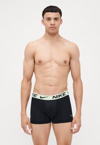 Zwarte boxershorts gemaakt van rekbare stof met een mintgroene Nike-logo tailleband. Heeft een strakke pasvorm en een conventioneel snijontwerp.