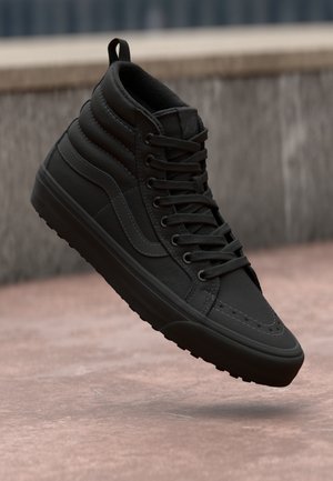 Svart høyhælte sneakers med en glatt læroverdel, forsterkede sømmer, snøring og strukturert gummisåle.