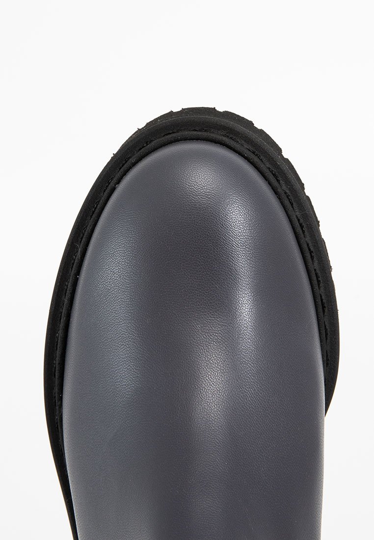 Szara skórzana boot z zaokrąglonym czubkiem, czarną gumową podeszwą i teksturowanym brzegiem. Gładka powierzchnia bez widocznych wzorów ani okucia.