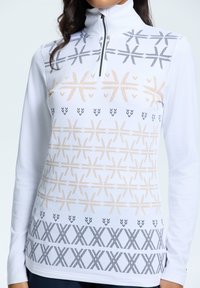 Biała bluzka z długim rękawem i wysokim kołnierzem, zdobiona geometrycznymi wzorami w kolorach złotym, czarnym i szarym, z półzamkiem przy kołnierzu.