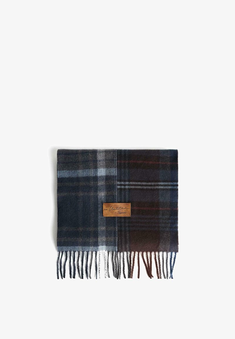 Geruit wollen sjaal in donkerblauw en grijs, met een leren label en witte franjes aan de randen. Het materiaal lijkt zacht met een comfortabele textuur.