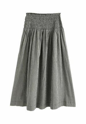 Jupe à carreaux noirs et blancs avec une large ceinture smockée et un tissu lâche et froncé sous la taille.