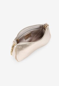 Bolso de mano metálico dorado con una textura suave, forma curva y acento de cadena. El interior tiene un bolsillo con cremallera y un forro de un color claro.