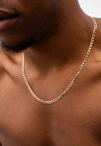 Goldene Kettenhalskette mit dicken Gliedern, polierte Oberfläche. Eng am Hals getragen, hautnah, zeigt Textur und Designdetails.