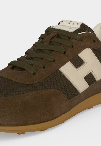 Baskets marron et vert avec logo blanc "H" sur le côté et étiquette "Hogan" sur la languette, composées de matériaux en suède et mesh avec une semelle gomme.