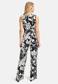 Zwart-wit bloemenprint jumpsuit met mouwloos ontwerp, keyhole detail aan de achterkant en wijd uitlopende broeken. Zachte stof met een relaxte pasvorm.