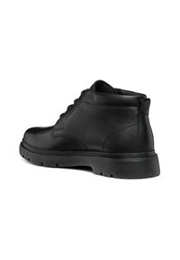 Botas de cuero negro hasta el tobillo con un acabado suave, punta redonda, diseño de cordones y suela de goma texturizada para mejorar la tracción. Refuerzo en la parte trasera para mayor soporte.