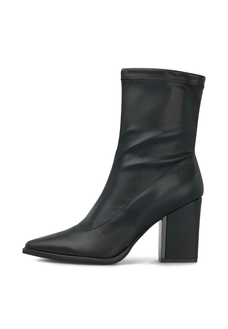 Bota de cuero negra hasta el tobillo con punta afilada y tacón grueso sobre fondo blanco, vista lateral.