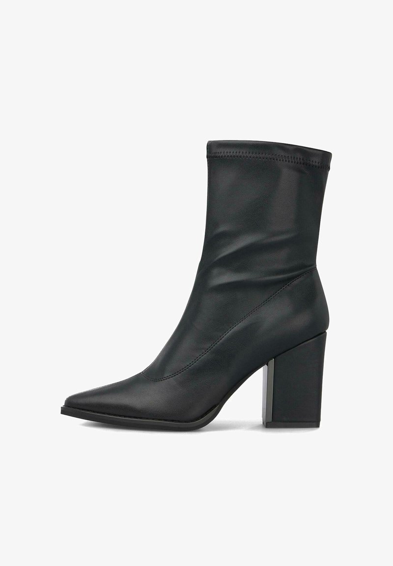 Bota de cuero negra hasta el tobillo con punta afilada y tacón grueso sobre fondo blanco, vista lateral.