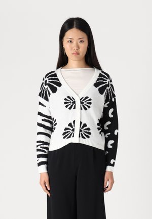 Black and white knitted cardigan with floral and abstract patterns, v-neckline, button closure, and ribbed cuffs. Mid-cropped design.