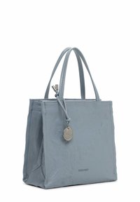 Light blue leather tote bag with smooth texture, short handles, and a silver hardware accent featuring a circular tag. Square shape.
