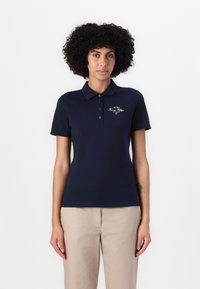 Marineblå polo skjorte laget av bomull med krage-design, med en plasse for to knapper og brodert merkevarelogo på brystet.