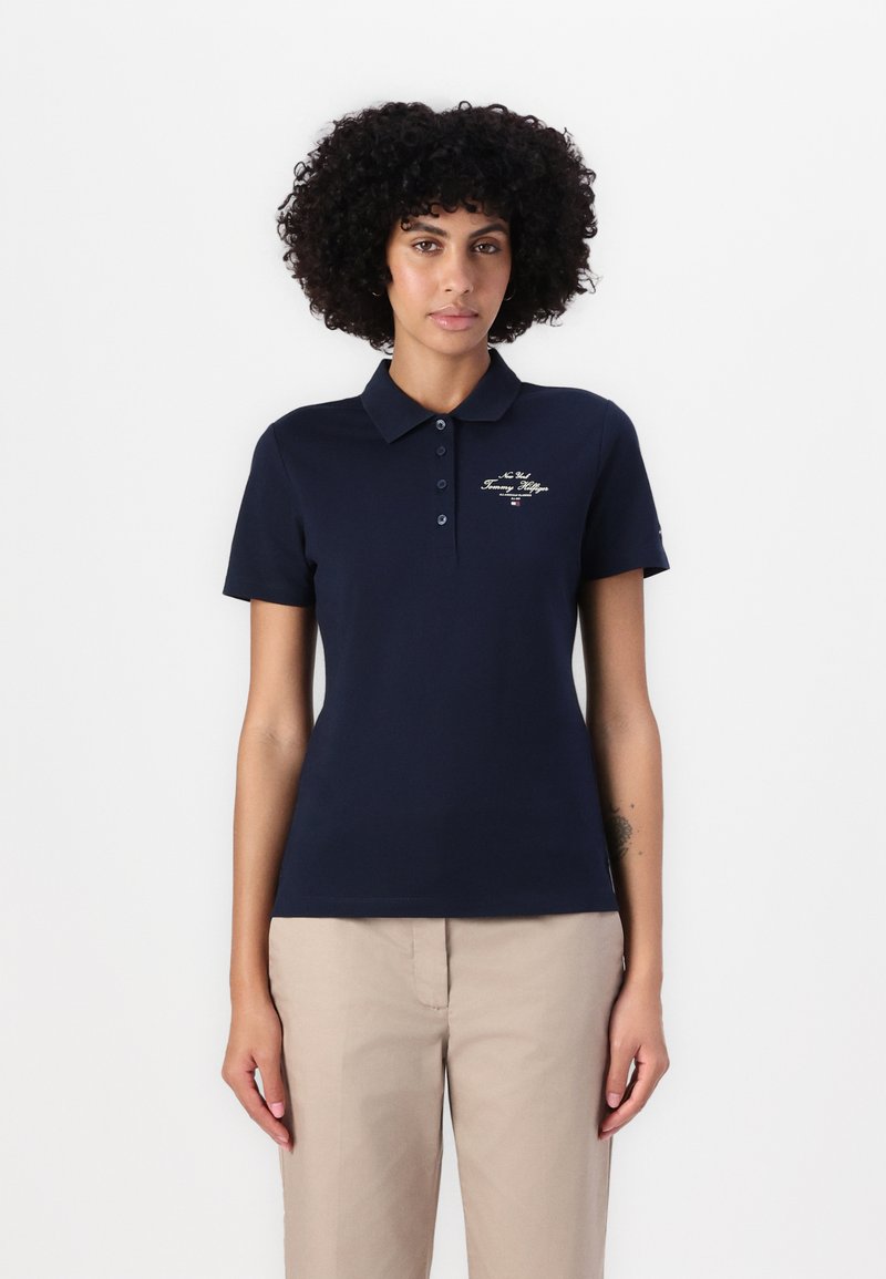 Marineblå polo skjorte laget av bomull med krage-design, med en plasse for to knapper og brodert merkevarelogo på brystet.