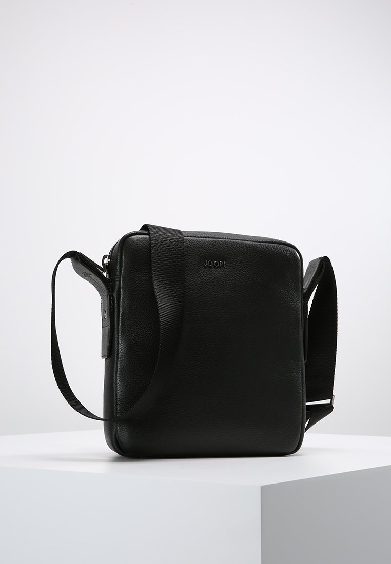 Borsa a tracolla nera in pelle, di forma quadrata, superficie testurizzata, tracolla regolabile e un logo sobrio impresso sul davanti.