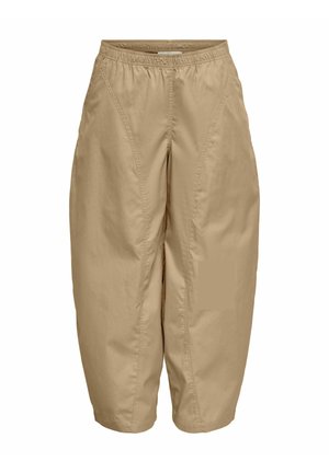 Pantalon beige court avec taille élastique et poches latérales, présentant des coutures visibles à l’avant et une coupe ample à jambes larges.
