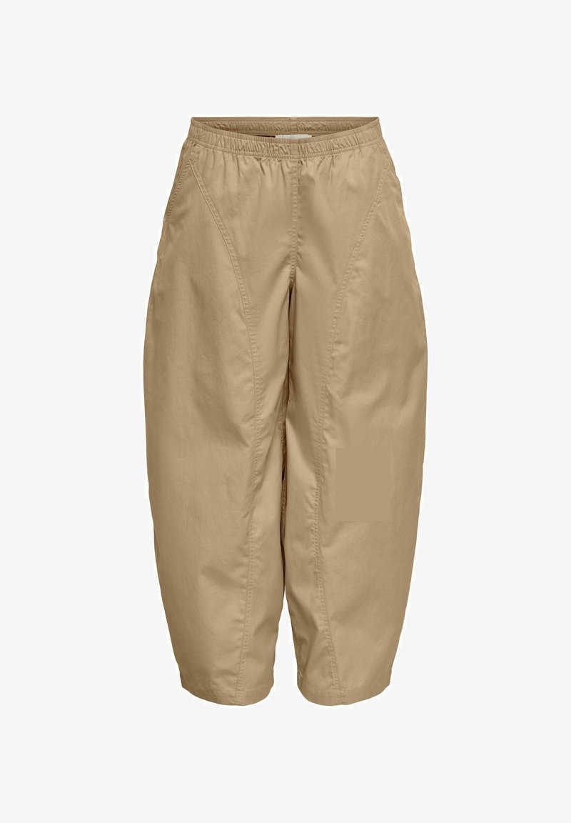 Pantalon beige court avec taille élastique et poches latérales, présentant des coutures visibles à l’avant et une coupe ample à jambes larges.