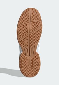 Suela de zapato Adidas con un fondo de goma de color marrón que presenta un diseño de espiga, texturizada para proporcionar agarre y con ranuras anguladas para una mejor tracción.