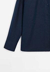 Chemise bleu marine à manches longues en tissu texturé avec une fermeture à boutons, dotée d'un col classique et d'un ourlet droit.