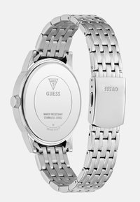 Zegarek ze stali nierdzewnej z bransoletą o srebrnym odcieniu oraz okrągłą kopertą. Posiada gładkie, polerowane dno i wygrawerowane logo marki.