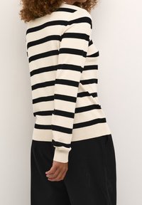 Schwarz-weißer gestreifter Pullover, weicher Strickstoff, taillierte Passform, lange Ärmel, gerippte Bündchen und Saum, sichtbare Nähdetails.