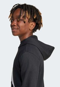 Schwarzer Kapuzenpullover mit Kapuze, ausgestattet mit einer Vordertasche und einem hellen Design auf der Rückseite. Der Stoff wirkt weich und hat eine lässige Passform.