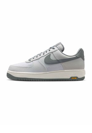 Lage grijs-witte Nike sneaker met grijze veters, gestructureerde bovenkant, grijze Swoosh, Vibram buitenzool en witte tussenzool met label "Air".