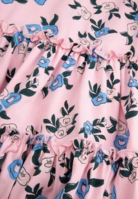 Różna tkanina w kwiatowy wzór z niebieskimi i kremowymi kwiatami oraz zielonymi liśćmi. Falbany wzdłuż szwów. Miękka tekstura.