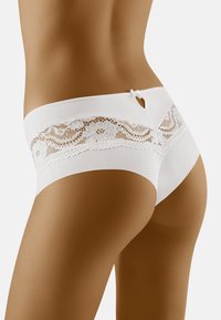 Mutandine bordate in pizzo bianco con una fascia liscia, dettaglio a chiave decorativo e motivo floreale in pizzo sul retro, caratterizzate da una consistenza morbida.