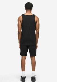 Czarny zestaw składający się z topu na ramiączkach i szortów, wykonany z miękkiej bawełny. Prosty design, bez rękawów, o luźnym kroju z subtelnymi detalami szwów.