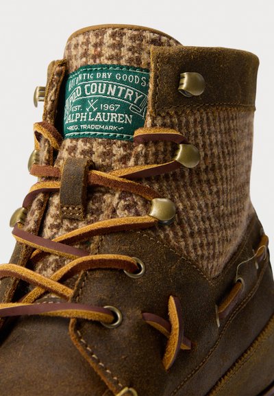 Brune lær- og uldvandrestøvle med messingøjer og grøn Polo Country Ralph Lauren-label på tungen.
