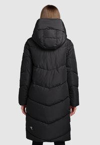 Svart vadderad jacka med hög krage och huva, med chevronmönster och långa ärmar. Lätt och varmt material.