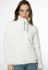 Giacca in pile bianca con colletto alto, zip frontale completa e lacci neri. Presenta una texture a coste e tasche laterali. Fit casual.