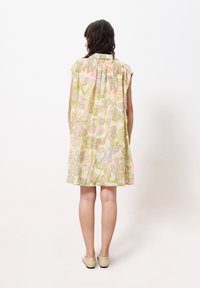 Blumenmuster, kurzärmliges Kleid in Pastellfarben mit lockerer Passform, das einen Kragen und ein gefälteltes Rückendesign aufweist.