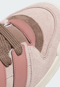 Svijetlopinkaste tenisice od velura i kože, s pletenim smeškim vezicama, teksturiranim smeškim akcentom i belim gumiranim đonom.