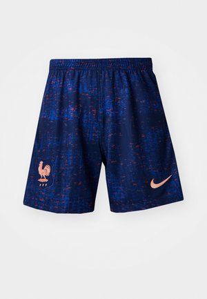 Nike športne kratke hlače v mornarsko modri z rdečim in modrim pikastim vzorcem, z roza petelinom logotipom in roza Nike swooshom na strani.