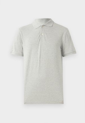Polo gris hecho de algodón suave. Presenta un cuello clásico, una tapeta de tres botones y manga corta. Textura lisa sin patrones.
