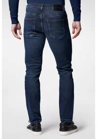 Ciemnoniebieskie dżinsy w slim fit, z pięcioma kieszeniami, subtelnymi przeszyciami i markową skórzaną naszywką na pasku.