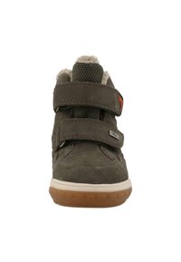 Grøn ruskindsko med to justerbare velcro-remme, en blød indersål og en gummisål med et struktureret grebsmønster.