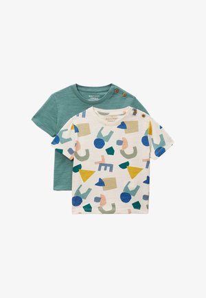 Deux t-shirts pour tout-petits, l'un vert uni et l'autre blanc avec des formes abstraites colorées, tous deux avec des boutons sur l'épaule.